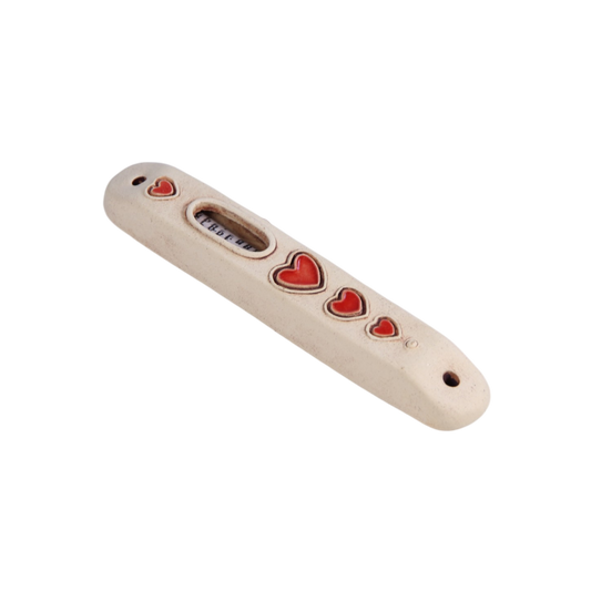 Beige ceramic mezuzah with a clear window and five red hearts of varying sizes arranged vertically along its length. - Hearts - Prague Judaica