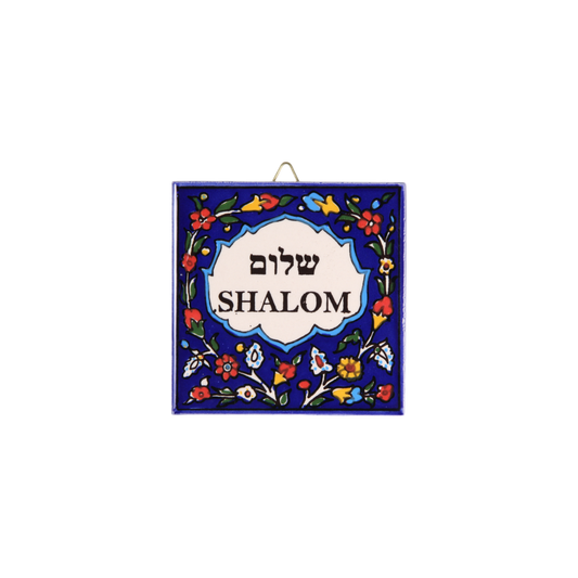 Square Armenian ceramic tile with deep blue background, colorful floral border, and white central panel featuring Hebrew and - Shalom - Y´all - Prague Judaica